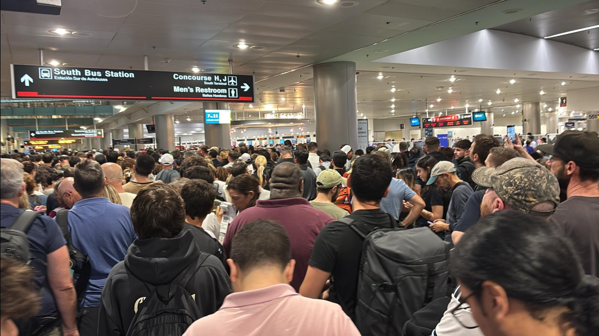 Passengers wait in line after Miami International Airport reopened Sunday evening.