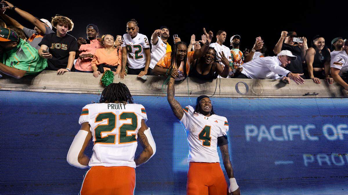 Miami Hurricanes running back Mark Fletcher Jr. (4) and linebacker Cam Pruitt (22) celebrate with fans after defeating the California Golden Bears in their NCAA college football game at the California Memorial Stadium on Saturday, Oct. 5, 2024, in Berkeley, Calif.