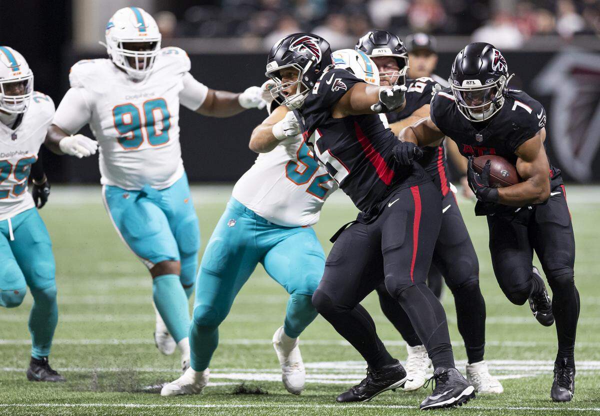 Miami Dolphins defensive tackle Zach Sieler (92) tries to tackle Atlanta Falcons running back Bijan Robinson (7) in the second half of their NFL game at Mercedes-Benz Stadium on Sunday, Oct. 26, 2025, in Atlanta, Ga.