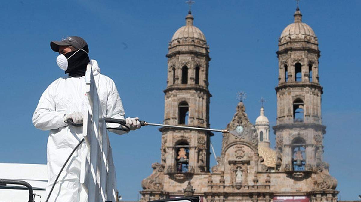 A healthworker sanitizes the area against the coronavirus outside the Basilica of Our Lady of Zapopan in Mexico.
