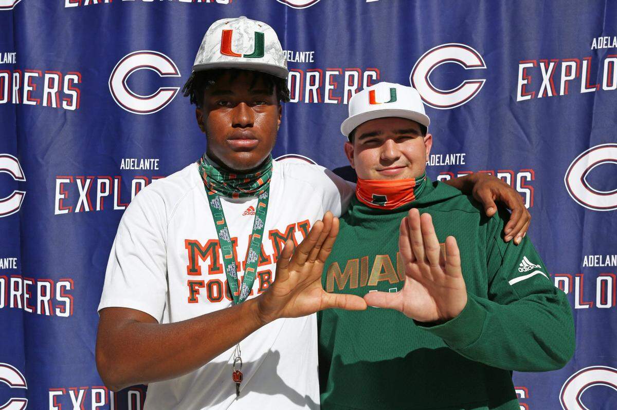 Jabari Ishmael, left and Ryan Rodriguez, do the “U” sign as they are photograph after signing National Letters of Intent committing to join the University of Miami football program during a ceremony at Christopher Columbus High School on Early National Signing Day in Miami, Florida, Wednesday, December 16, 2020.