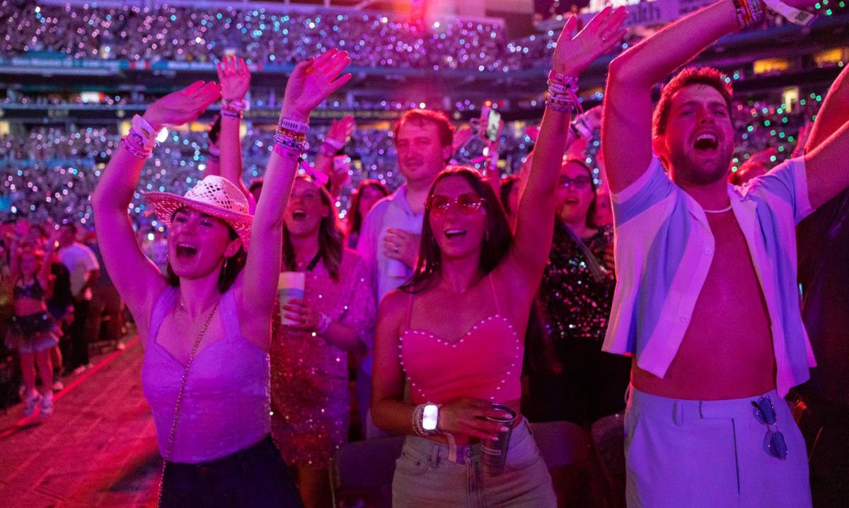 Fans sing and dance as Taylor Swift performs onstage during The Eras Tour at Hard Rock Stadium Miami Gardens on Oct. 18, 2024. It rained on this Friday night and during the Sunday, Oct. 20 date, making these Miami concerts “official rain shows,” Swift said from the stage.