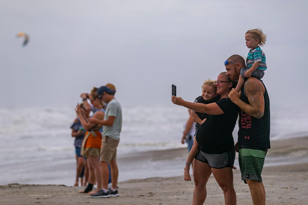 Beachgoers watch the waves wash onto Cocoa Beach as winds from the outer bands of Hurricane Dorian start to kick up the surf on Tuesday, Sept. 3, 2019.