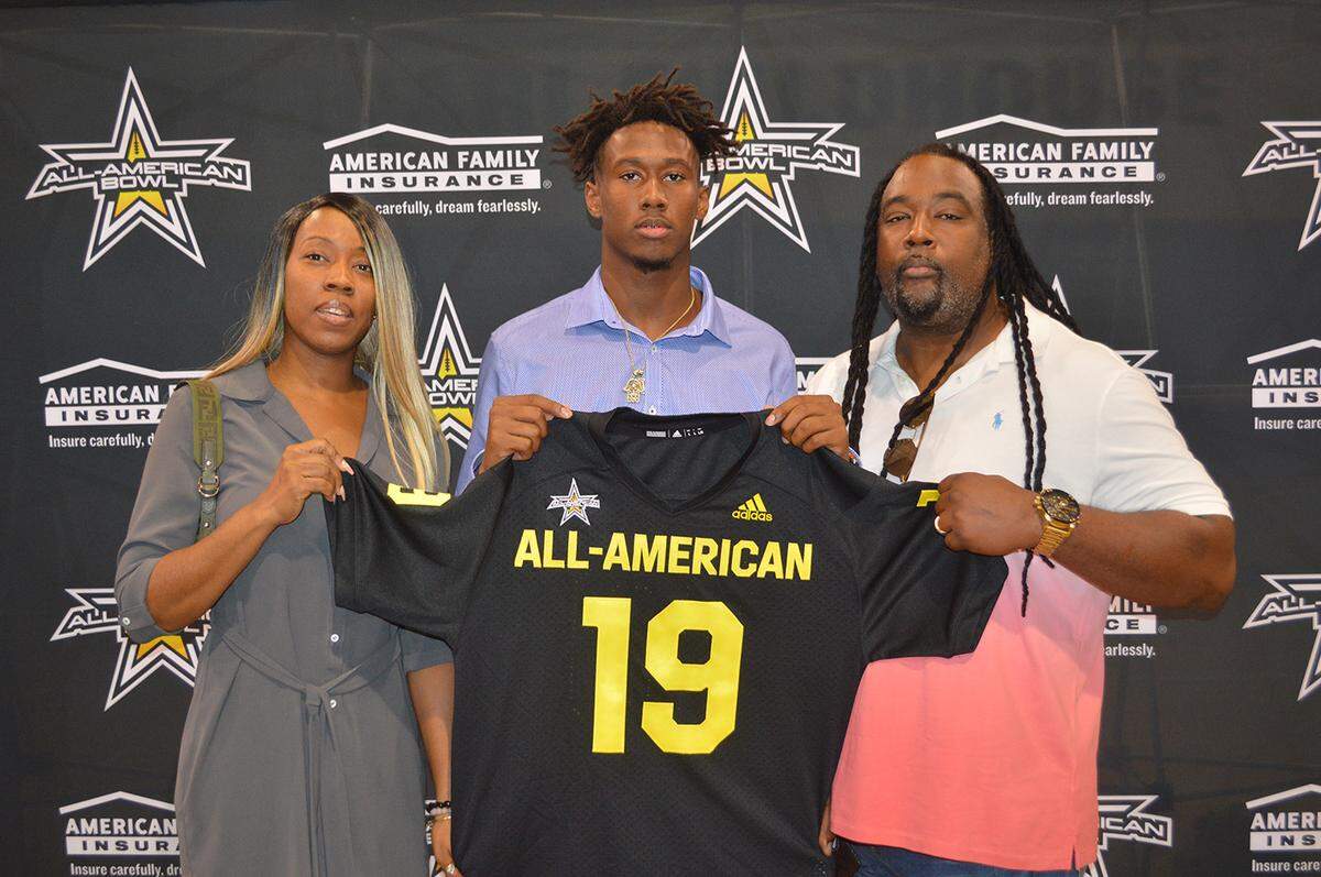 South Dade wide receiver Frank Ladson (center) shows off his All-American Bowl jersey while standing with his parents Natasha Ladson (left) and Frank Ladson Sr. (right).