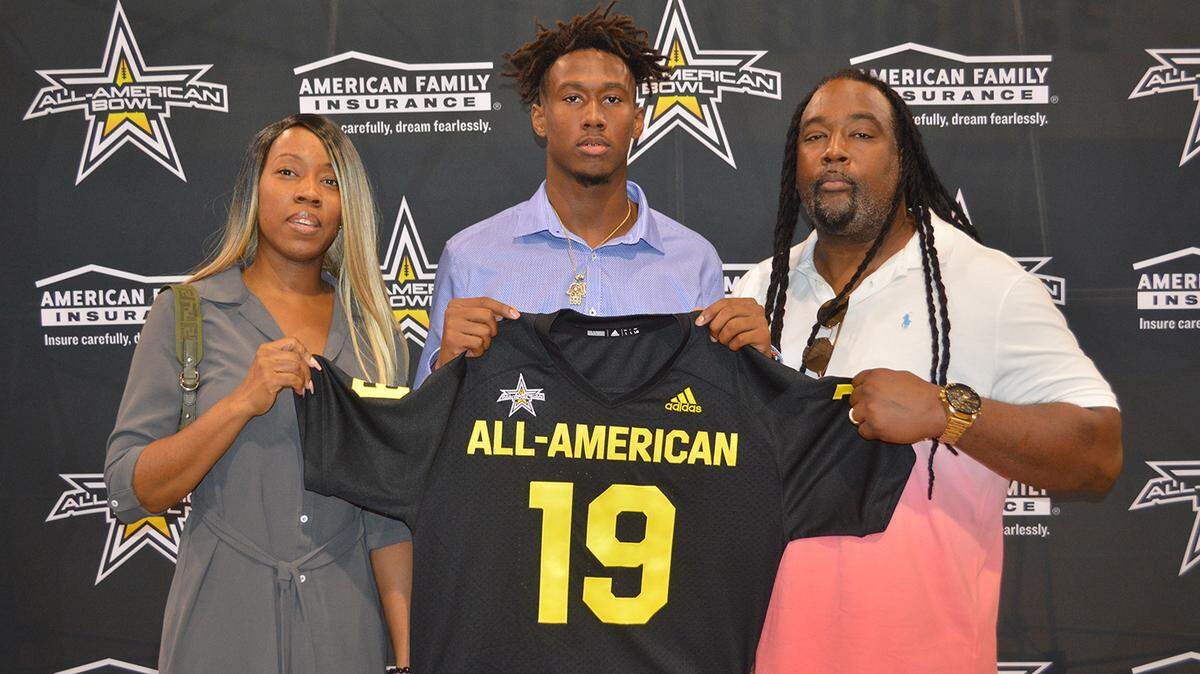 South Dade wide receiver Frank Ladson (center) shows off his All-American Bowl jersey while standing with his parents Natasha Ladson (left) and Frank Ladson Sr. (right).