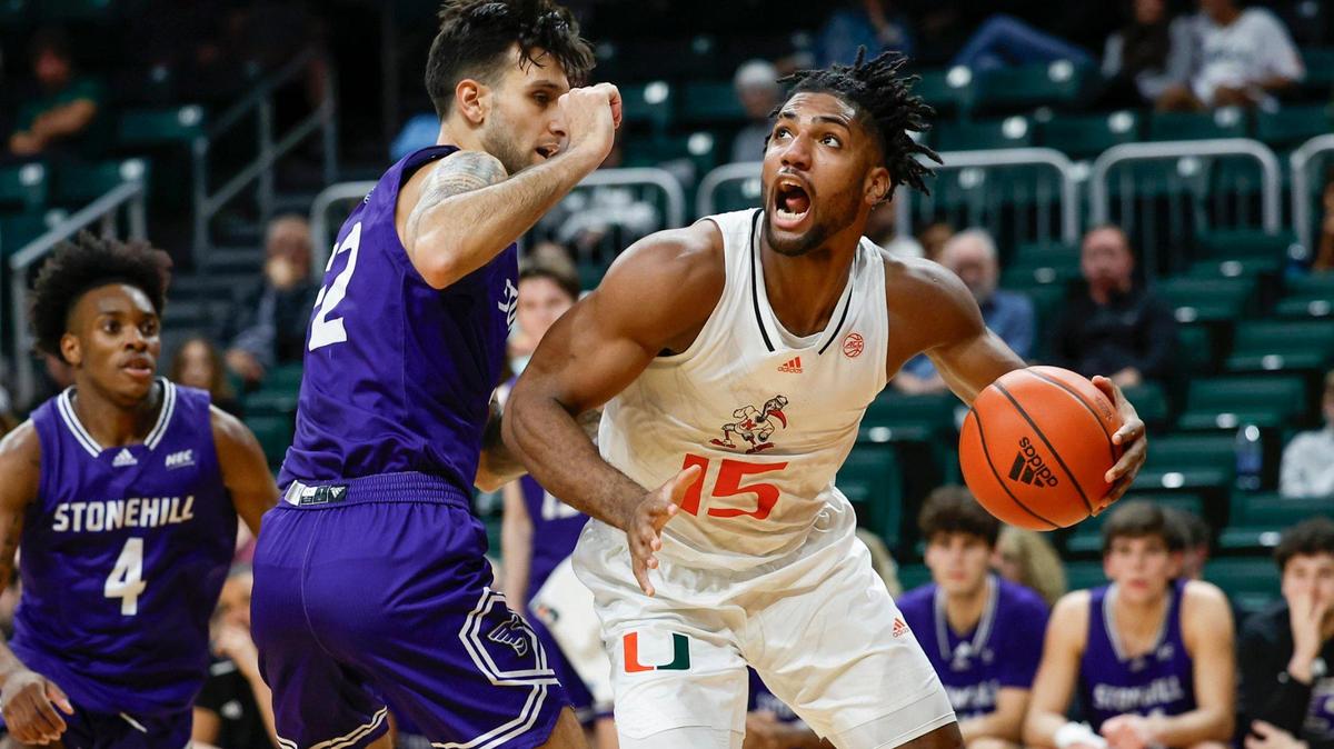 Miami Hurricanes forward Norchad Omier (15) drives to the basket as Stonehill Skyhawks forward Pano Pavlidis (22) defends during the first half at the Watsco Center in Coral Gables, Florida on Thursday, December 21, 2023.
