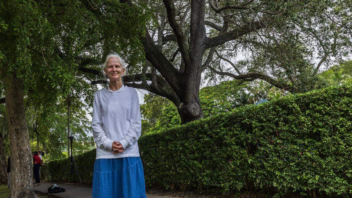 Resident Bonnie Bolton stands in the side walk by a centenary Oak tree situated inside the Crystal Academy, in the site that also is home of the St. James Evangelical Lutheran Church of Coral Gables and was bought by the Century Homebuilders Group in 2021 with plans to removes all trees and buildings to develop a project called Crystal, a 9-story mixed-use building, on Thursday, August 07, 2025.