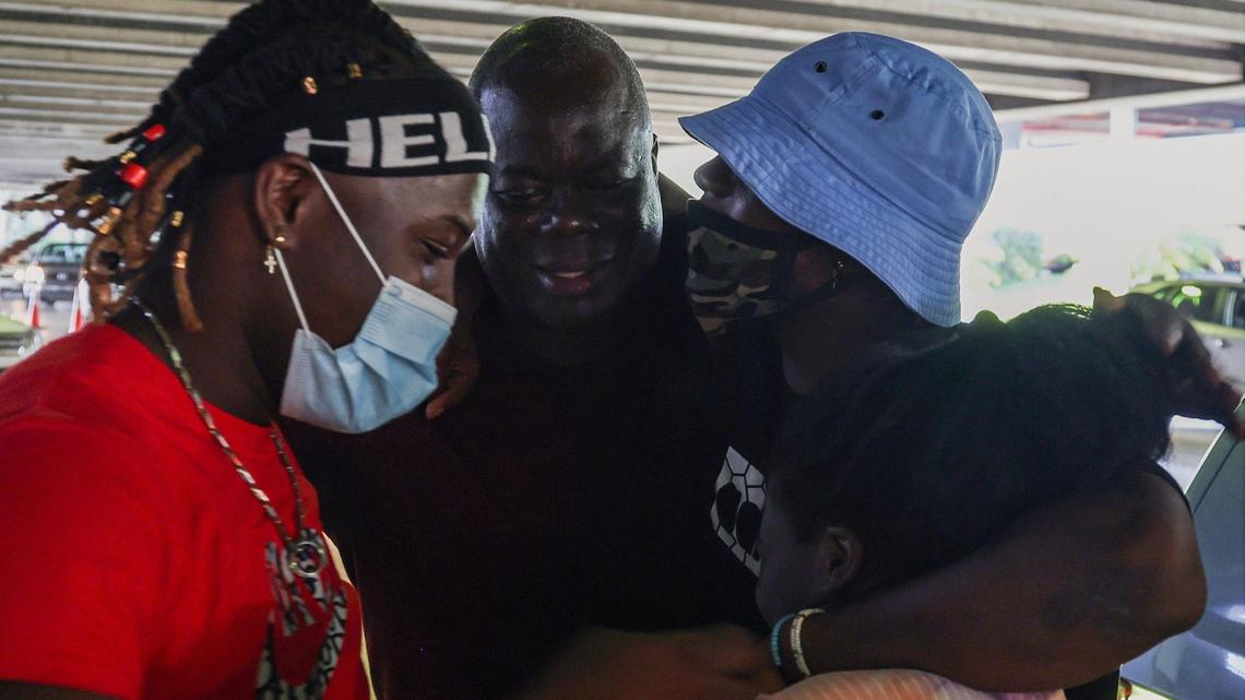 Brothers Lovinsky, 27, left, and John Nalus, 21, right, are greeted by their father, Calise Nalus, 57, upon their arrival in the United States on Thursday, July 15, 2021, after being detained in the Dominican Republic for just short of a year on an alleged drug charge.