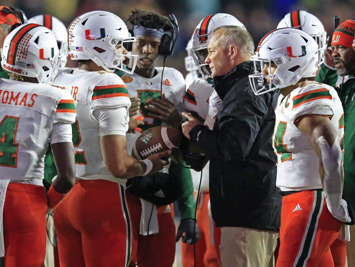 Miami Hurricanes head coach Mark Richt talks to quarterback Malik Rosier (12) during timeout in the second half as the University of Miami plays Boston College at Alumni Stadium in Chestnut Hill on Friday, October 26, 2018.