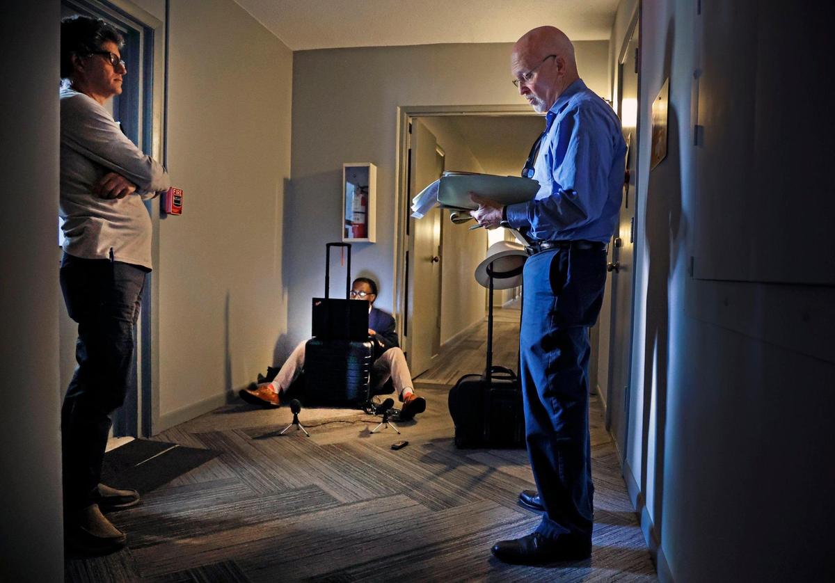 Attorney Brad Schandler, at right, takes bids during the auction of condominium unit 119A at Oakland Grove Village Condominium in Oakland Park, Florida on Tuesday, February 27, 2024. Court reporter Gary Siffort, of Esquire Deposition Solutions, seated on the floor takes notes as Mauricio J. Riquer owner of Max Rigz Enterprises Inc., a residential contractor company, offers bids.
