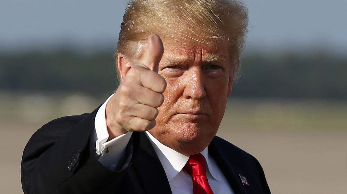 President Donald Trump gives thumbs up as he steps off Air Force One 
