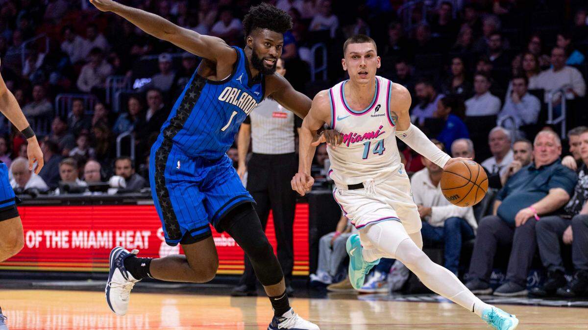 Miami Heat guard Tyler Herro (14) drives past Orlando Magic forward Jonathan Isaac (1) during the first half of an NBA game at Kaseya Center on January 27, 2025, in Miami.