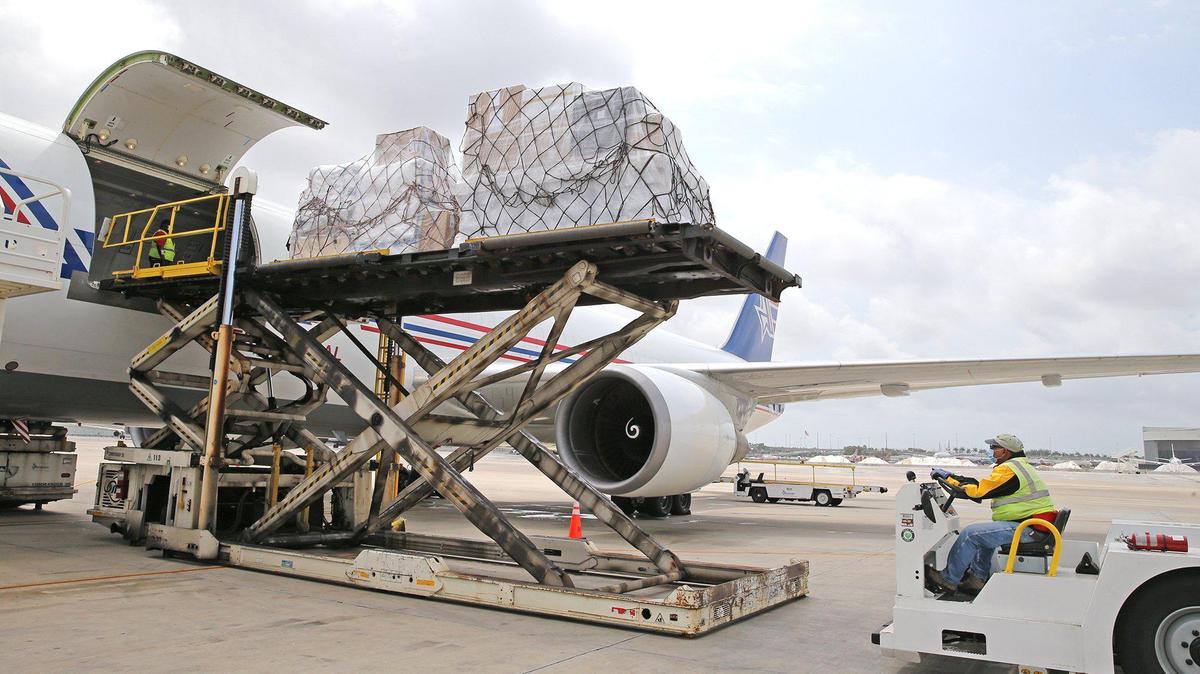 Amerijet Cargo workers unload cargo from an aircraft at Miami International Airport, April 17, 2020. Loads coming out of planes will be essentially stored in a local cold storage or dry warehouse space.