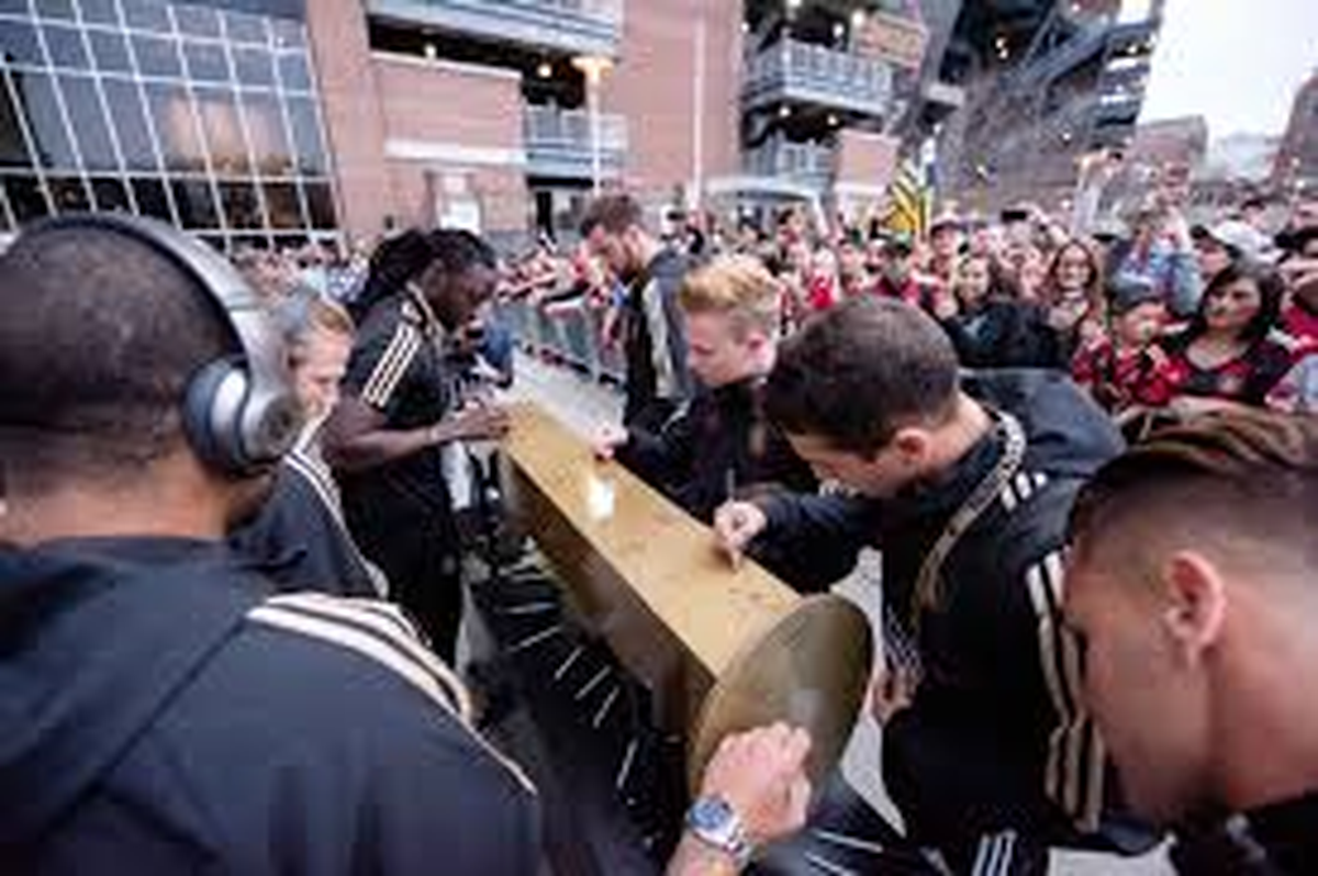 Atlanta United players and fans sign the Golden Spike before each game.