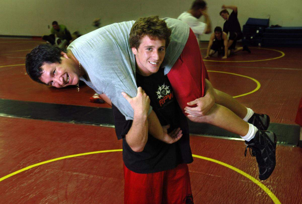 In this Nov. 8, 2006, file photo, Allen Held Jr. (A.J.) lifts his dad, Allen Held, onto his shoulders during wrestling practice at South Broward High School.