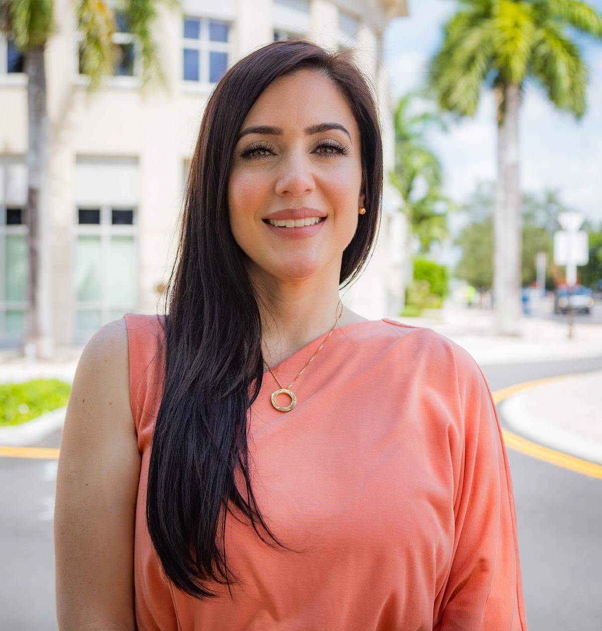 Roxanna Garay, who is running for mayor of Doral Mayor, stands in front of the Doral Government Center.
