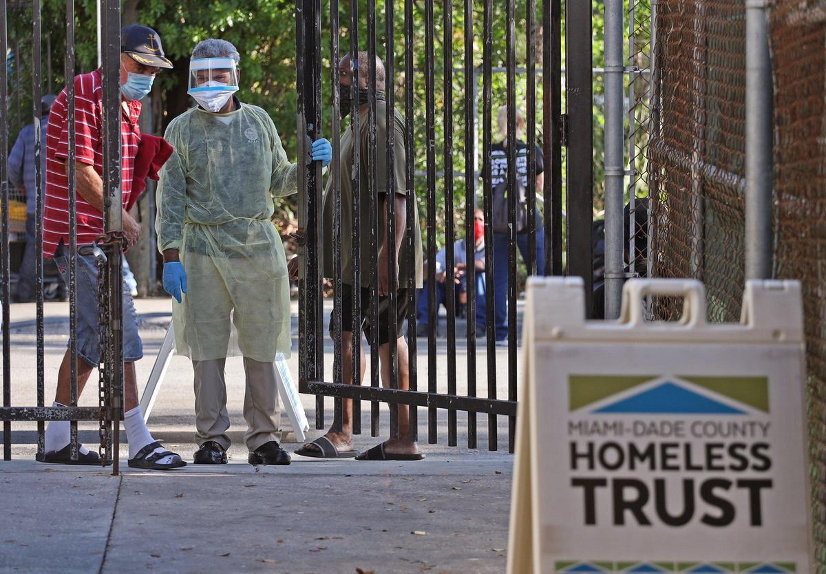 Lazaro Trueba, program administrator for the Lazarus Project, center, instructs a man to enter a testing site where Camillus Health Concern nurses and practitioners conducted COVID-19 testing at the Missionaries of Charity of Mother Teresa, a homeless shelter operated by the Archdiocese of Miami, as part of the Homeless Trust’s efforts to test people living on the street on Wednesday, May 6, 2020.