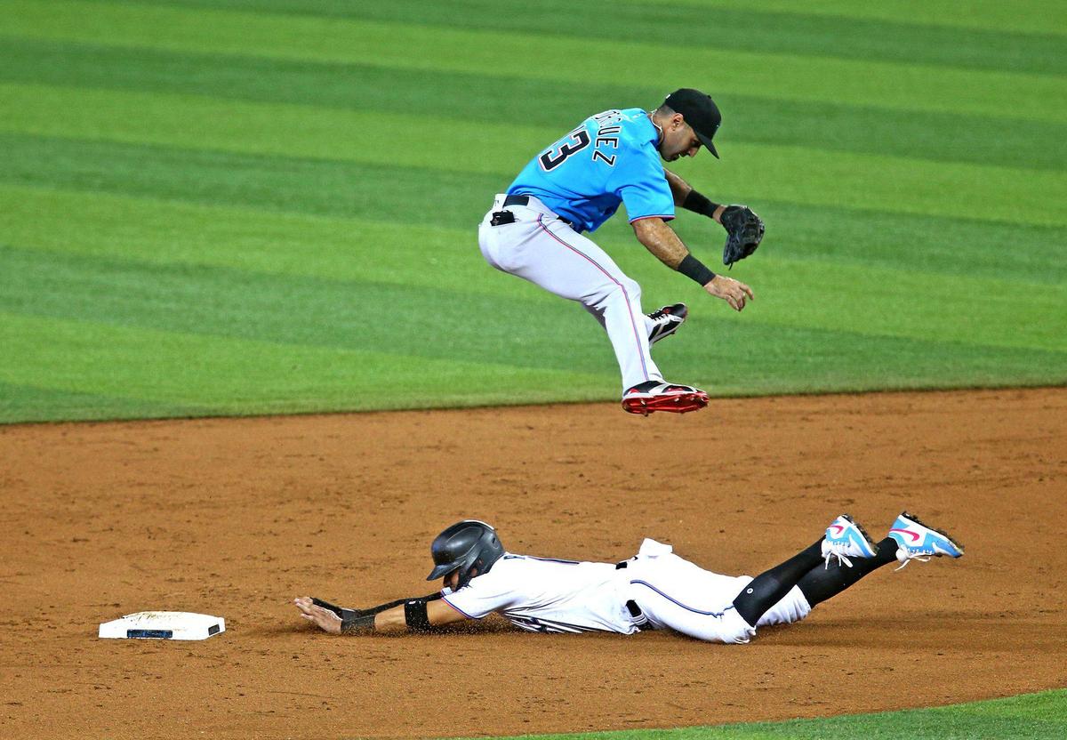 Miami Marlins Miguel Rojas (19) slides safely into second base as Sean Rodriguez (13) leaps after an overthrown ball in a simulated game at Marlins Park in Miami, Florida, July 13, 2020.