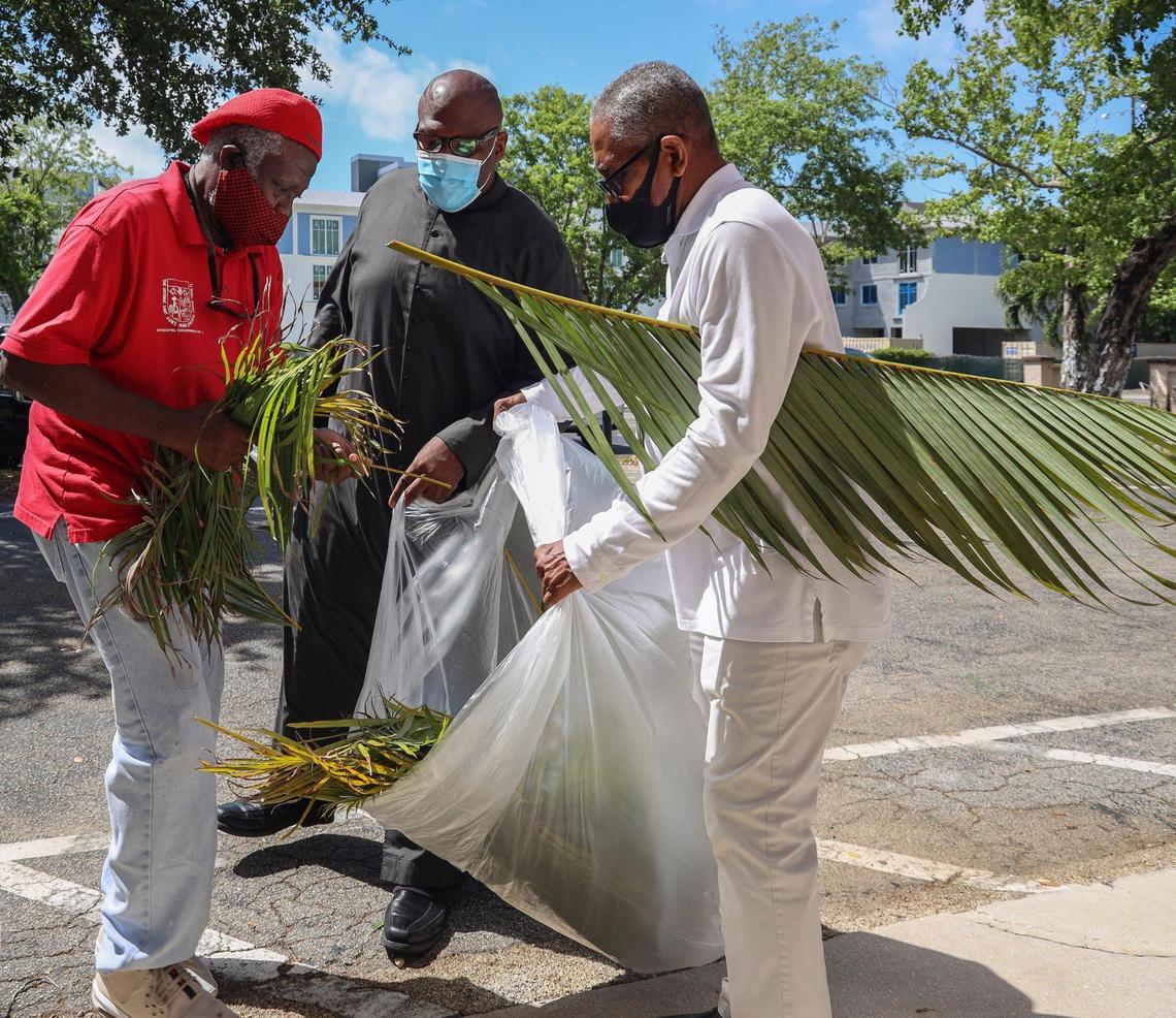 North Miami resident Enos Darling II, left, helps Julius Wade, of Margate, right, gather palms while Pastor Denrick Rolle assists on Sunday, March 28, 2021, as Historic St. Agnes Episcopal Church held a drive-thru Palm Sunday event during the start of Holy Week in Miami’s Historic Overtown neighborhood.