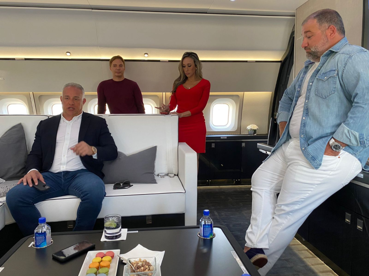 John H. Ruiz, left, with Ben Shirazi, right, and Diana Diaz, middle right, in the theater of Ruiz’s Boeing 767.