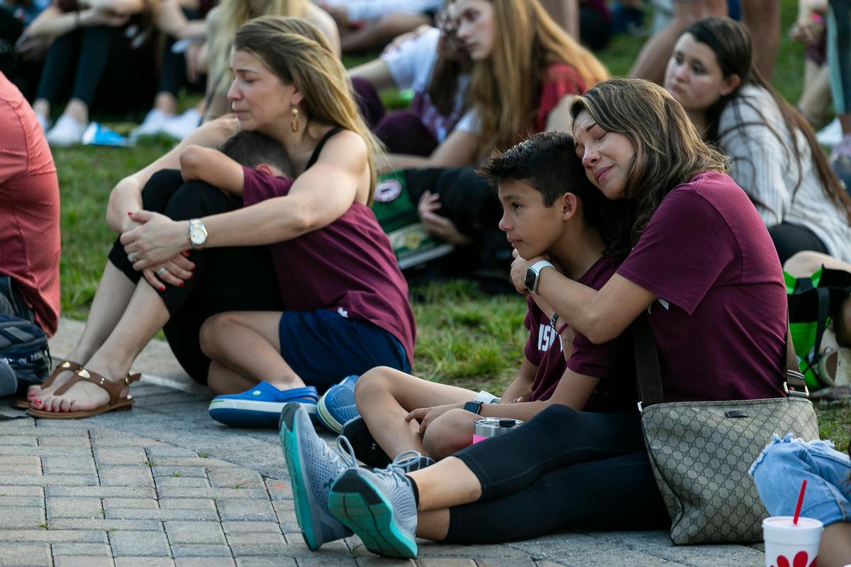 From left: Heidi Roque, Gustavo Negron, 9, Brayden Laughlin, 9, and Natalia Echavarria, attend an interfaith ceremony to remember the 17 victims killed at the Marjory Stoneman Douglas High School shooting on the two-year anniversary in Parkland, Florida, on Friday, February 14, 2020.