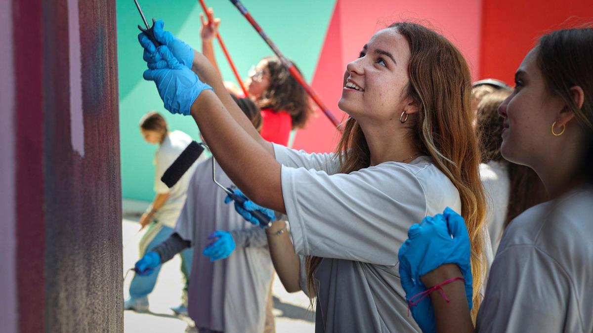 Valentina Mena (centro), de la preparatoria Miami Beach, y Anabella Corbuleaneo pintan un mural en un tanque de agua el 26 de abril de 2023, en Miami Beach Public Works. El poema de Mena fue seleccionado por el festival de poesía O, Miami y un colectivo con sede en Madrid para ser pintado en dos tanques de agua cerca de la escuela.