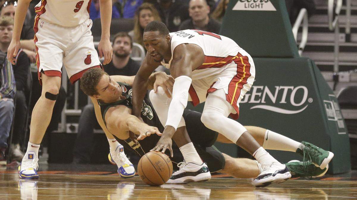 Milwaukee Bucks’ Brook Lopez, center, and Miami Heat’s Bam Adebayo reach for the ball during the first half of an NBA basketball game Friday, March 22, 2019, in Milwaukee. (AP Photo/Jeffrey Phelps)