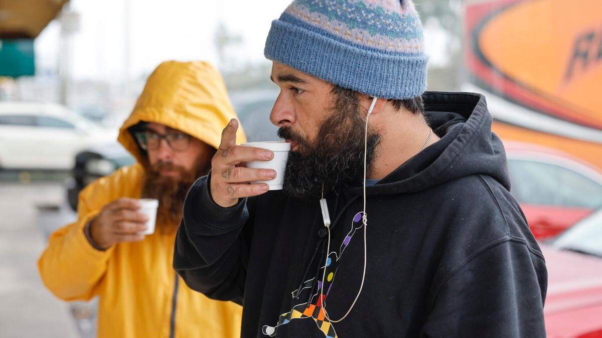 Bundled against the cold, Erik Bethencourt, 34, sips a cafecito in front of a cafe’s ventanita along Bird Road in Miami, Florida on Jan. 24, 2025.