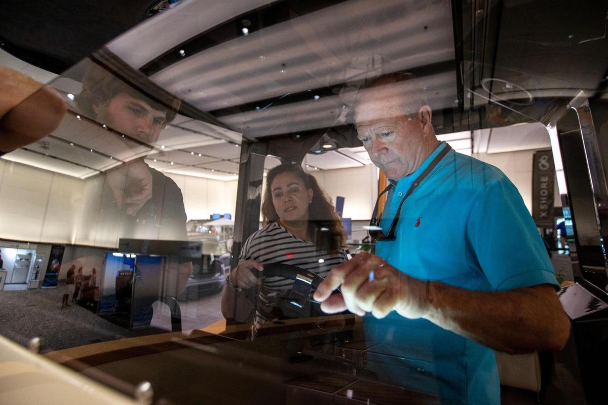 Customers examine an electric boat from a company called Hercules Mobility during the Miami International Boat Show.