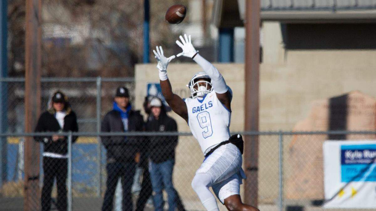 Bishop Gorman’s Elija Lofton jumps to receive the ball and score a touchdown at the state championship game against Bishop Manogue at Carson High School on Nov. 19, 2022. Manoguevgorman04