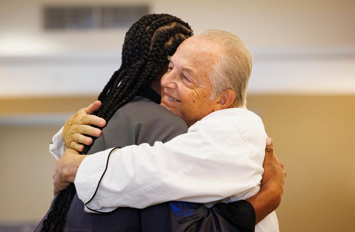 Frank Ferrara, culinary instructor, right, hugs graduate Angela Banks during her graduation ceremony for the Kitchen Cook program on Wednesday, Sept. 11, 2024, at Camillus House in Miami.