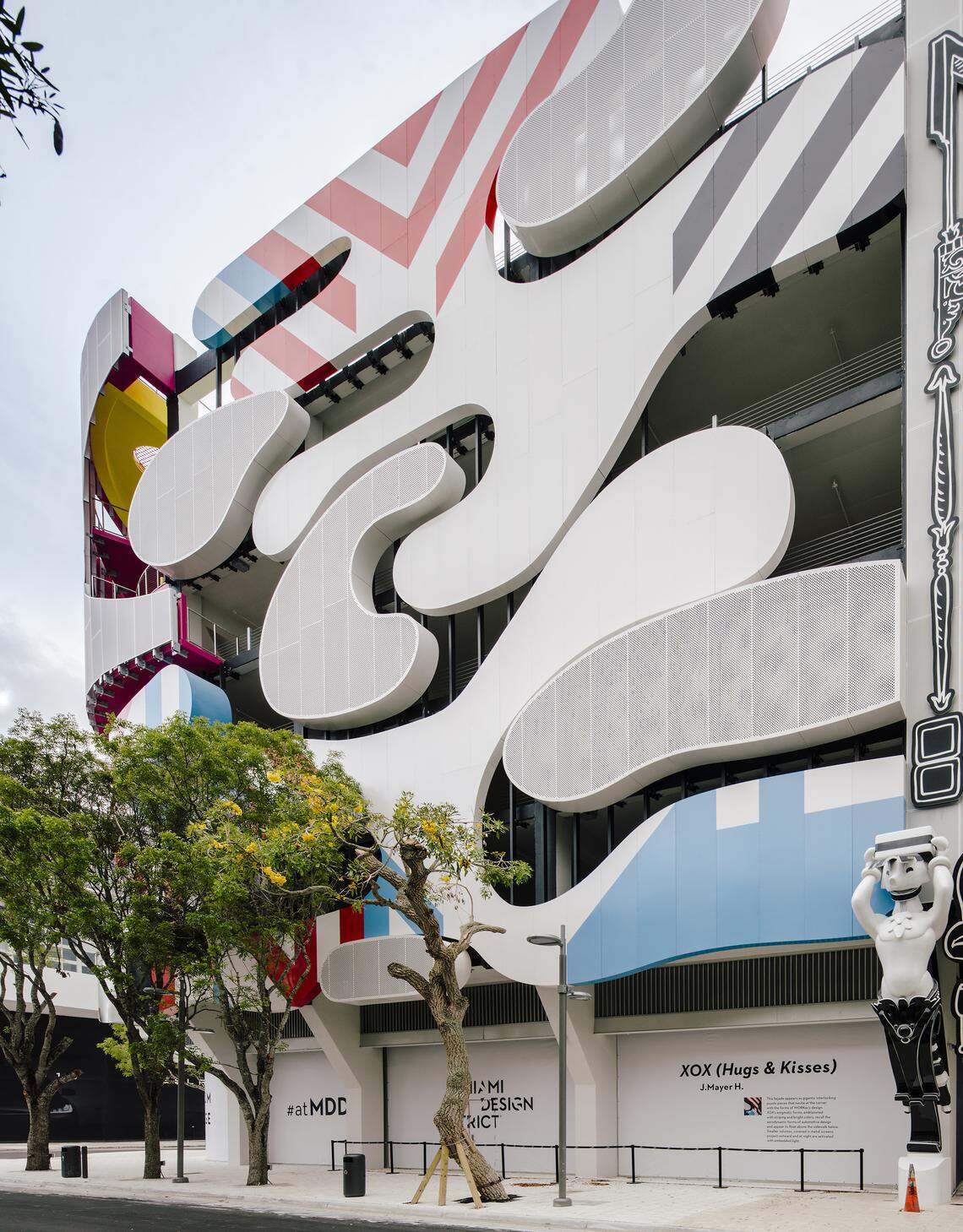 The Museum Garage's "XOX (Hugs and Kisses)" facade, by Berlin architects J.MAYER.H., consists of interlocking puzzle pieces inspired by the shapes and colors of automobile bodies .