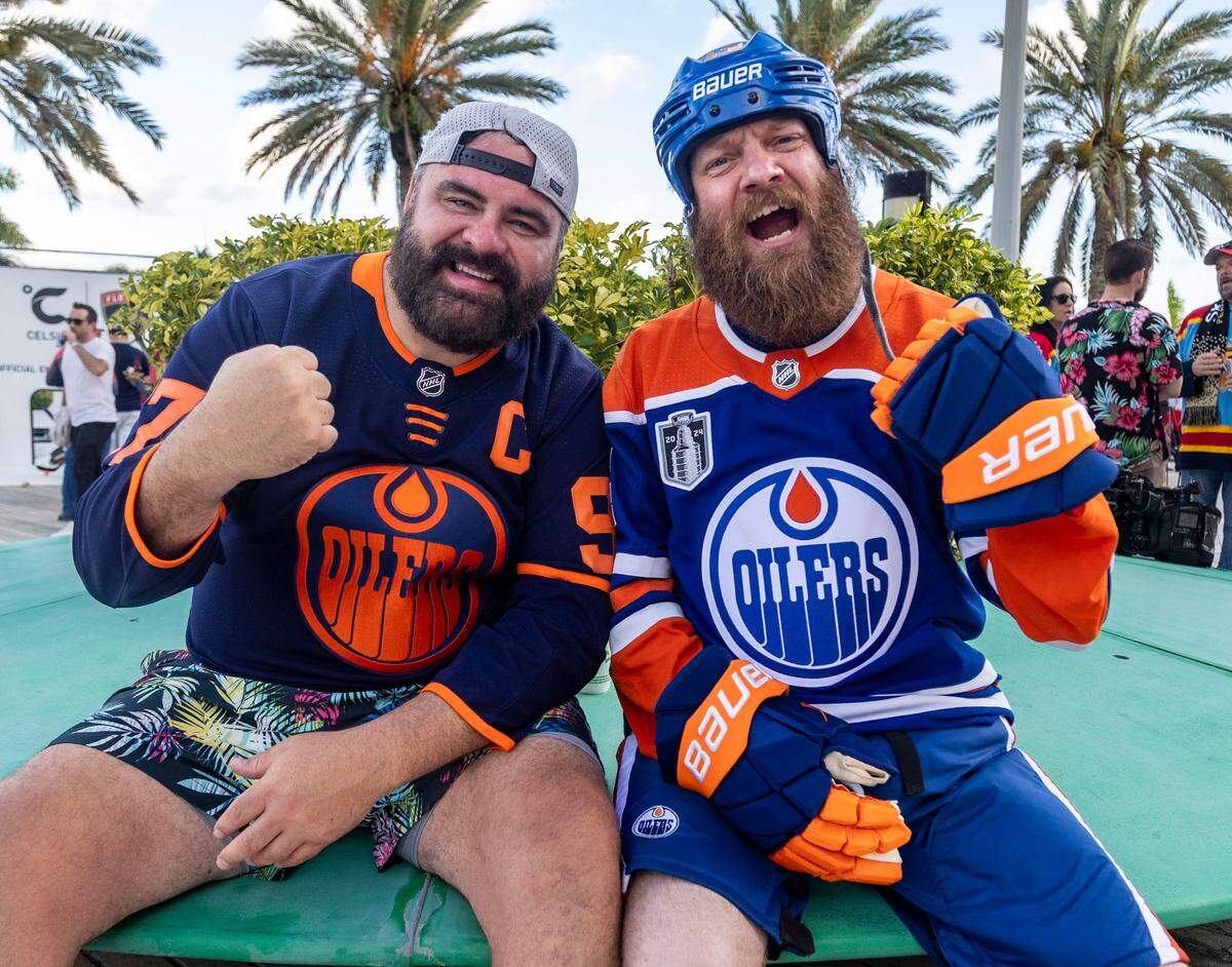 Oiler fans Sam Roth, left and Kris Black , right chant for the Oilers outside the main entrance of Amerant Bank Arena