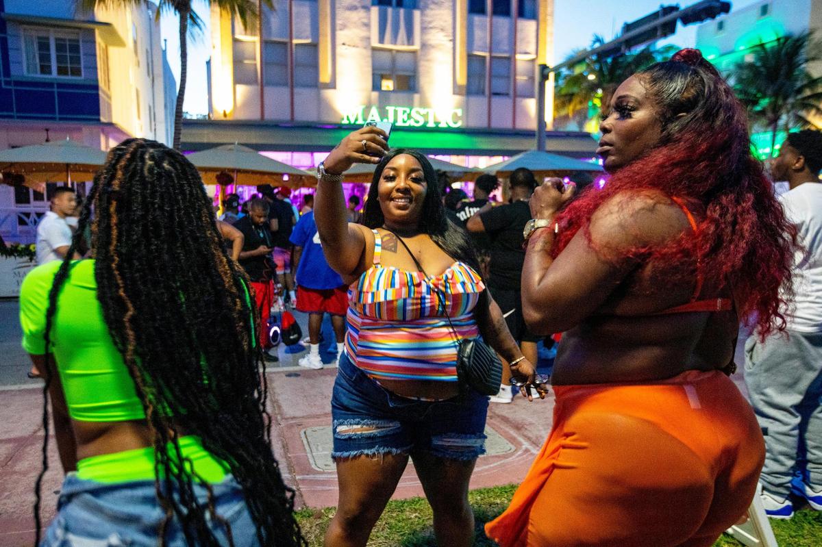 A woman takes a selfie before curfew on Ocean Drive in Miami Beach, Florida, on Sunday, March 28, 2021.