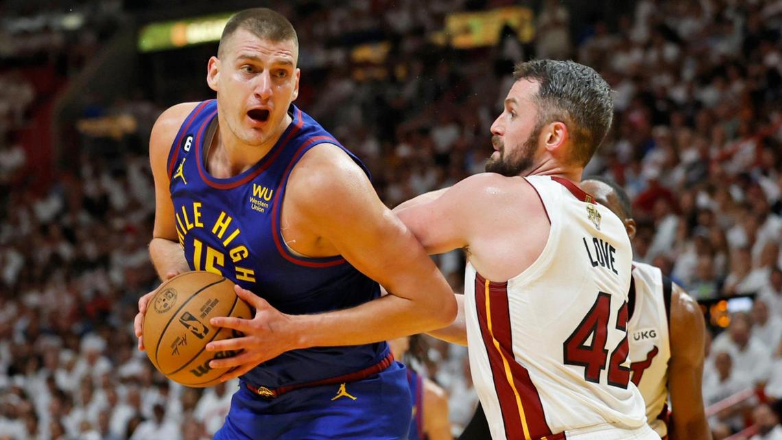 Denver Nuggets center Nikola Jokic (15) drives to the basket as Miami Heat forward Kevin Love (42) defends during the first half of Game 3 of the NBA Finals at the Kaseya Center in Miami on Wednesday, June 7, 2023.