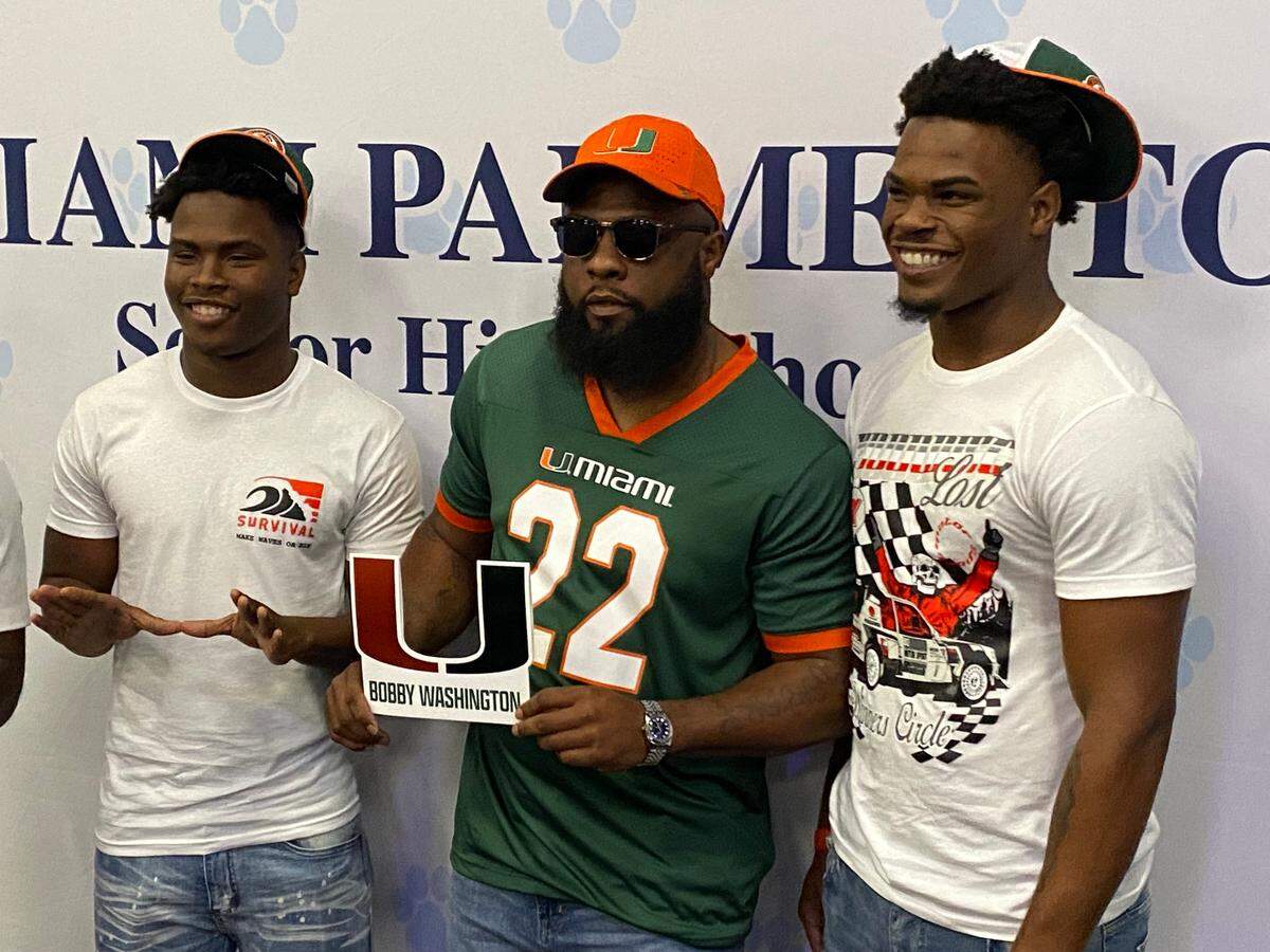 Miami Palmetto’s Robby and Bobby Washington Jr., seen here with their father, former Miami Killian star running back Bobby Washington, Sr., signed with the University of Miami on Wednesday.