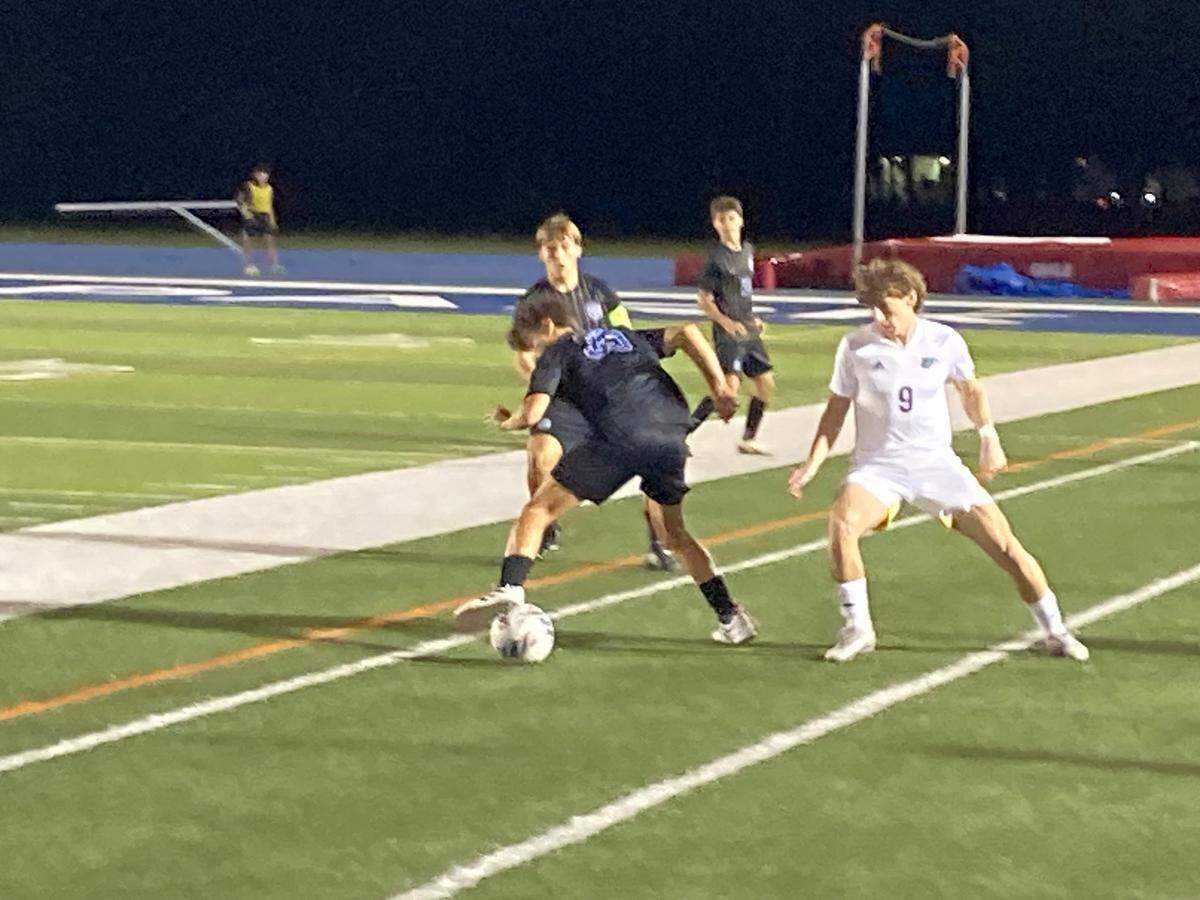 Downtown Doral’s Andres DeJesus battles Divine Savior defenders for possession during Wednesday night’s Region 4-3A boys’ soccer final at Tropical Park.