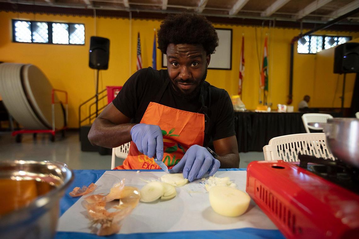 Jevanni Milien cuts onions during a cooking class by Eatwell Exchange, a Miami nonprofit that teaches kids and families how to prepare healthy meals from their homeland, Little Haiti Cultural Complex, Sept. 7, 2024.