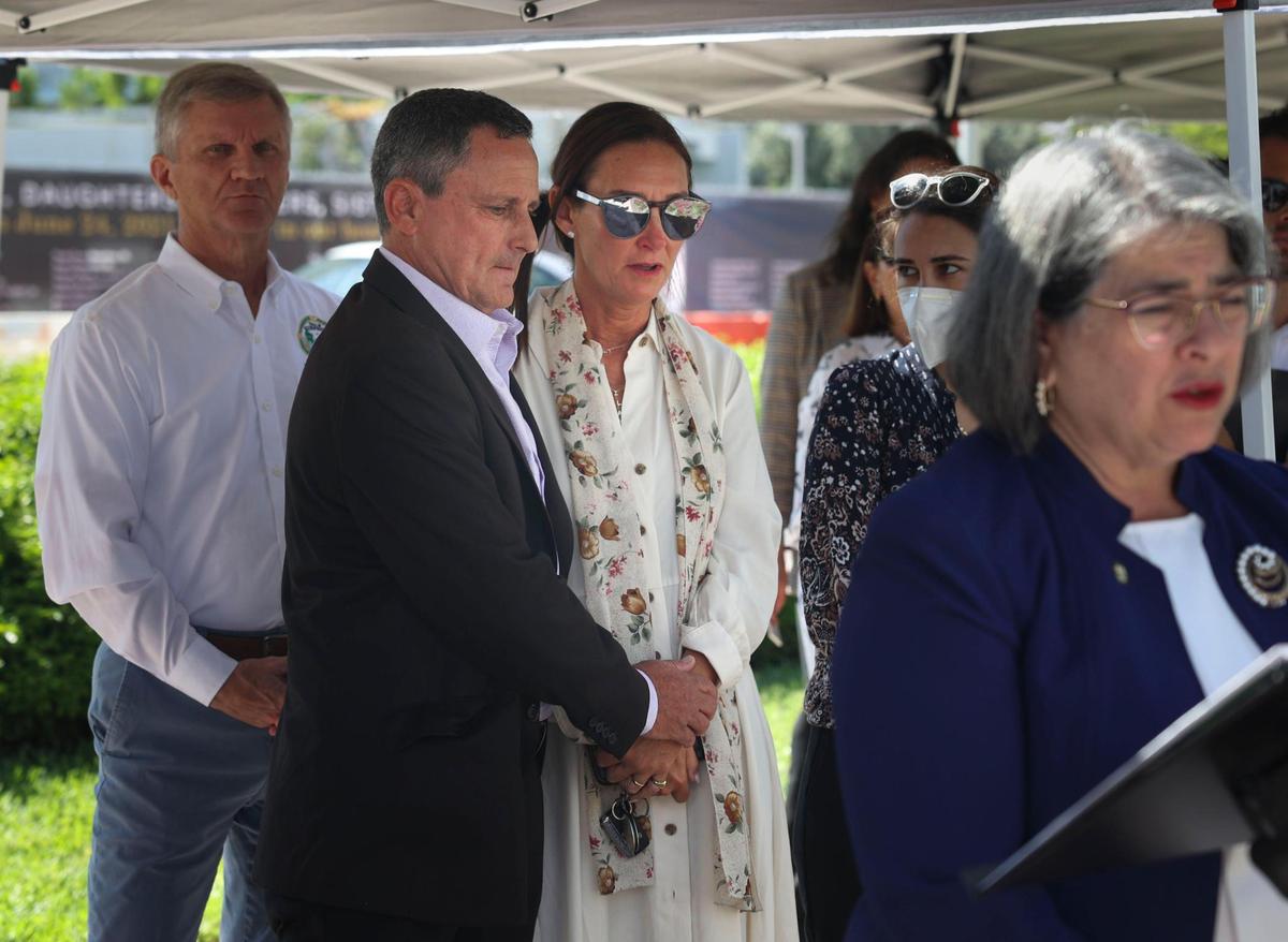 Pablo Langesfeld, left, comforts Ronit Naibryf during a press conference unveiling temporary memorial banners at the site of the former Champlain Towers South condo building in Surfside on Thursday, May 12, 2022. Langesfeld lost his daughter, Nicole, and Naibryf lost her son, Ilan, in the June 24 condo collapse that killed 98 people.