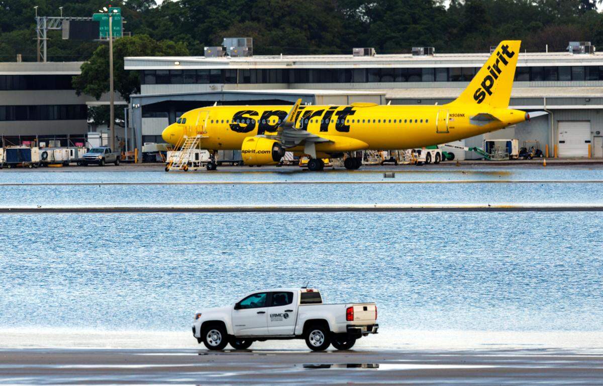 A Spirit Airlines airplane is parked as a truck drives by at Fort Lauderdale-Hollywood International Airport on Thursday, April 13, 2023.
