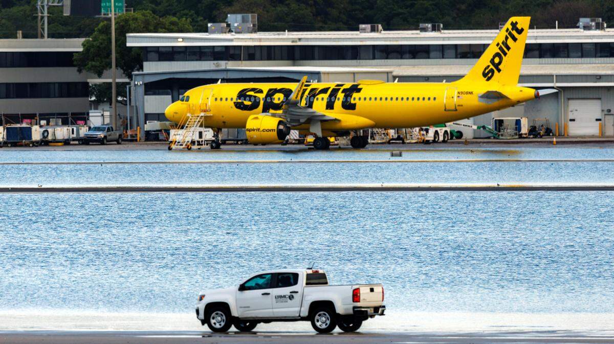 A Spirit Airlines airplane is parked as a truck drives on the tarmac at the Fort Lauderdale-Hollywood International Airport on Thursday, April 13, 2023.