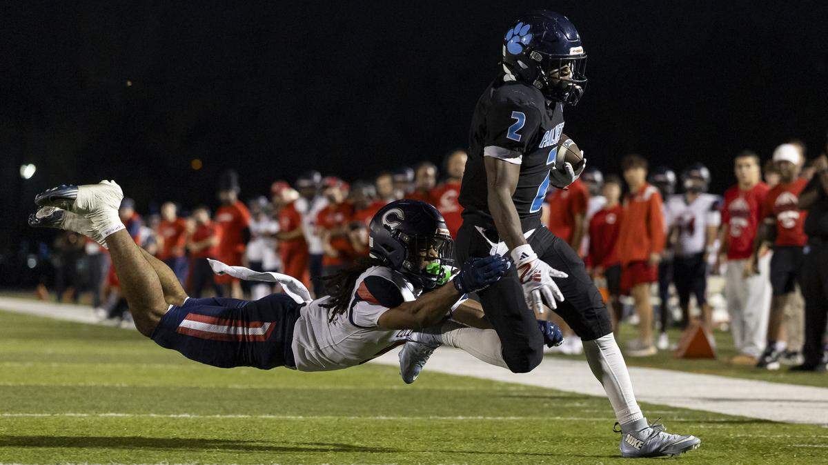 Palmetto Panthers running back Aiden Butler (2) scores a touchdown as Columbus Explorers safety Tedrick Lee (5) fails to stop him in the first half of their Region 4-7A quarterfinal high school football playoff game at Tropical Park on Friday, Nov. 21, 2025, in Miami, Fla.