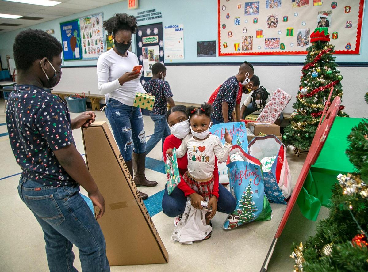 Tanesha Brown and her children check gifts they received from the Boys and Girls Club of Broward County and the Miami Herald’s Wish Book program during a visit to the club’s center in this file photo from December 2020.