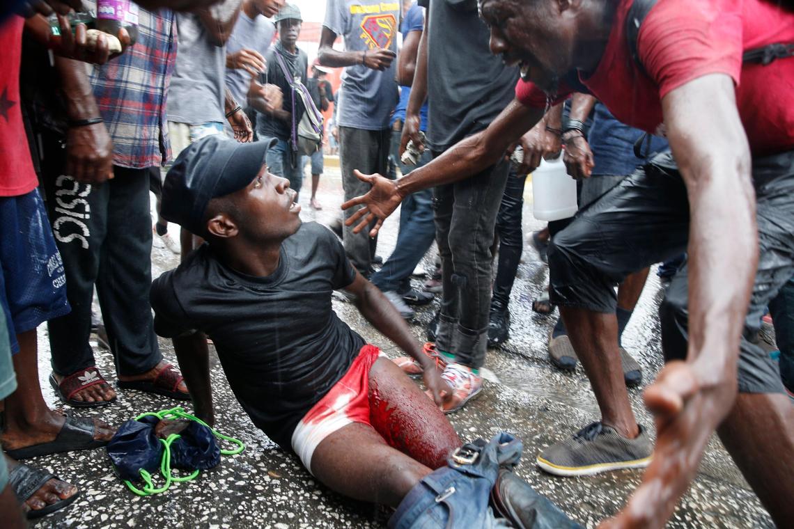 A man cries out over an injured fellow protester after police launched tear gas to disperse demonstrators,&nbsp;who set fires and chanted calls for Haiti’s president to resign, in Port-au-Prince, Haiti, Monday, Sept. 30, 2019.  