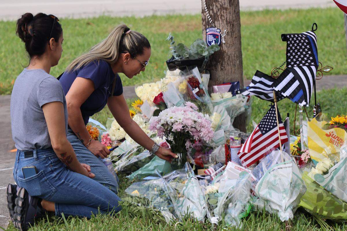 A memorial for fallen Deputy Devin Jaramillo continues to grow as mourners gather with candles, flags, flowers, rosaries, prayers and other token of remembrance on Monday, November 10, 2025 in Southwest Miami-Dade, Florida. 