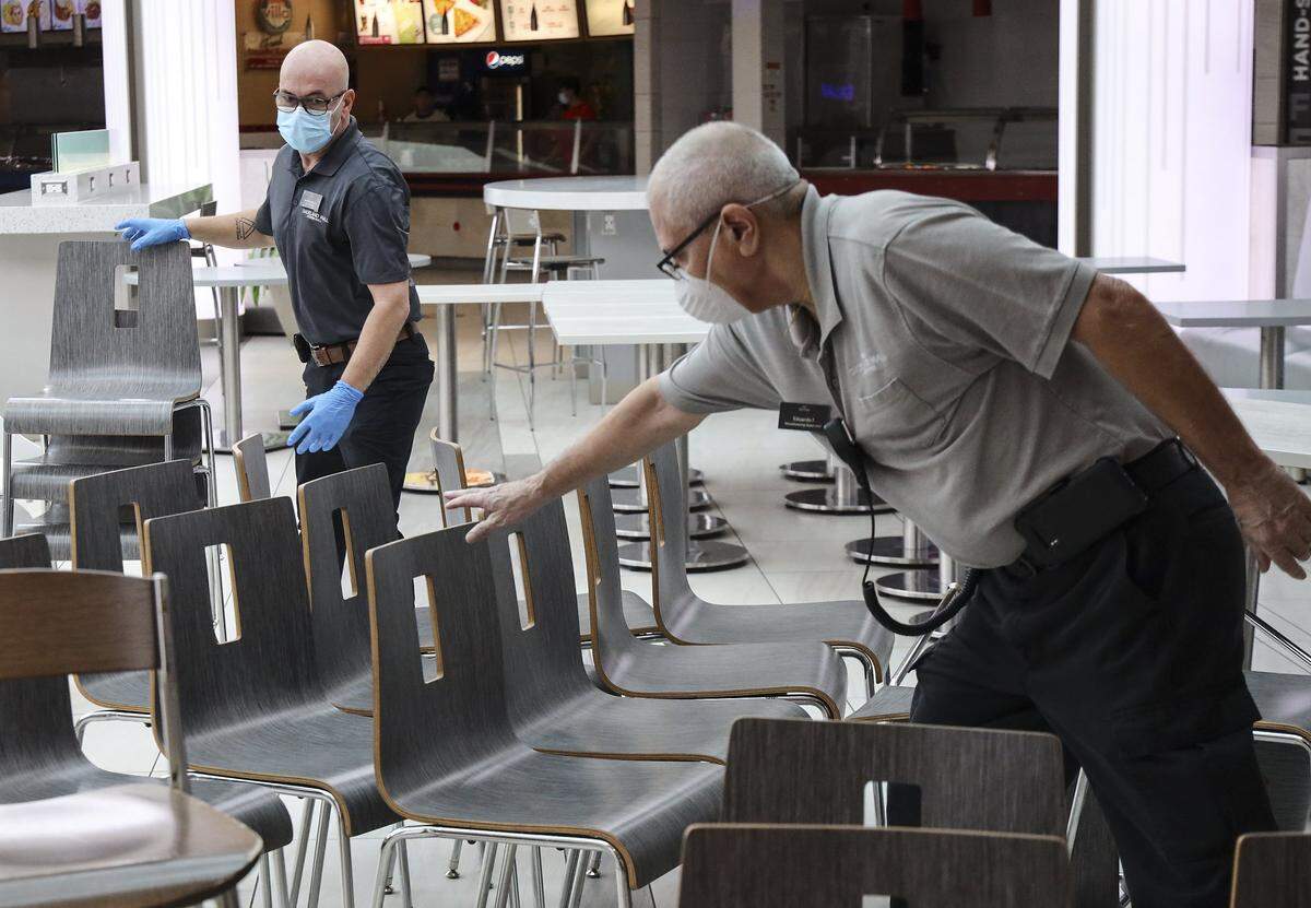 Workers clean the tables at Dadeland Mall in this May 2020 photo.