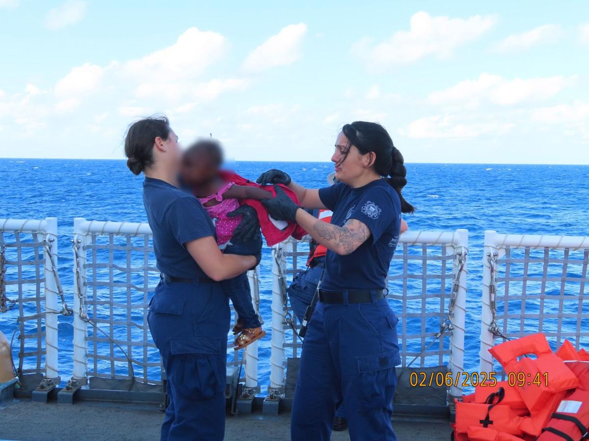 U.S. Coast Guard members care for an infant who was among 132 people stopped at sea on an overloaded migrant sailboat about 50 miles southeast of the Florida Keys Tuesday, Feb. 4, 2025.