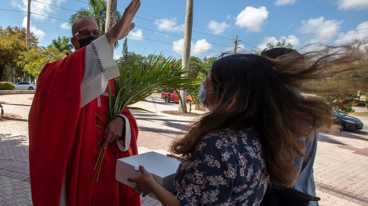 Father Marino bless a parishioner after bless the palms feast that falls on the Sunday before Easter at St. Marys Cathedral on Northwest Second Avenue and 75th Street in Miami on Sunday, March 28, 2021.