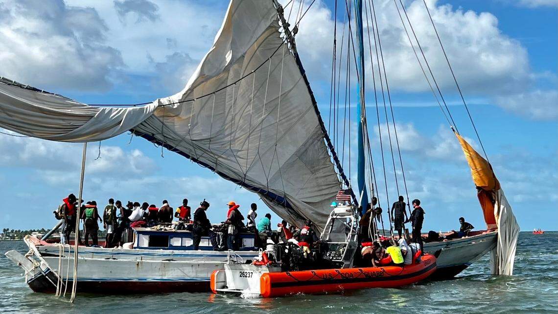 A boat carrying migrants is grounded next to a Coast Guard patrol vessel off Ocean Reef in north Key Largo Saturday, Aug. 6, 2022.