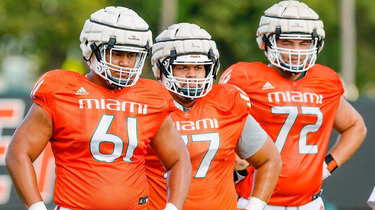 Miami Hurricanes linemen Francis Mauigoa (61), Logan Sagapolu (77) and Chris Washington (72) look on during practice drills at Greentree Field on the University of Miami campus in Coral Gables on Thursday, March 30, 2023.